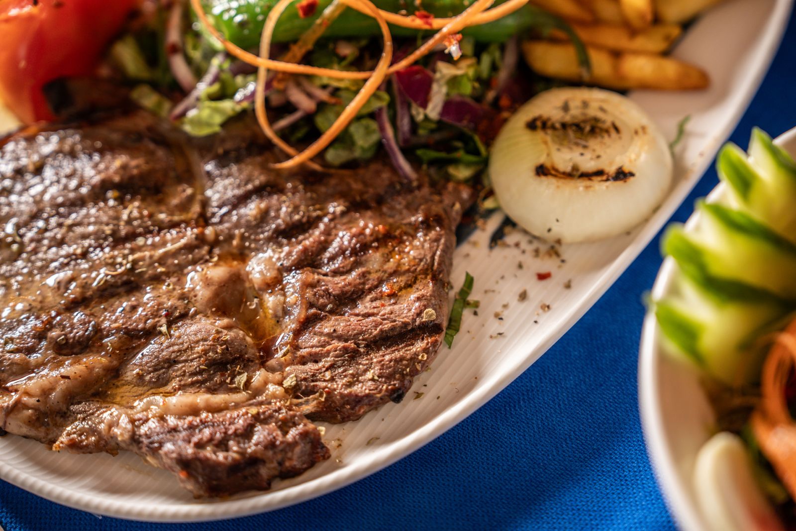 Izgara et, közlenmiş sebze, salata ve patates eşliğinde
